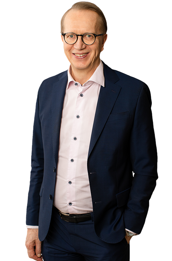 Janne Metsämäki standing in a dark suit with jacket open and hand in his pocket.