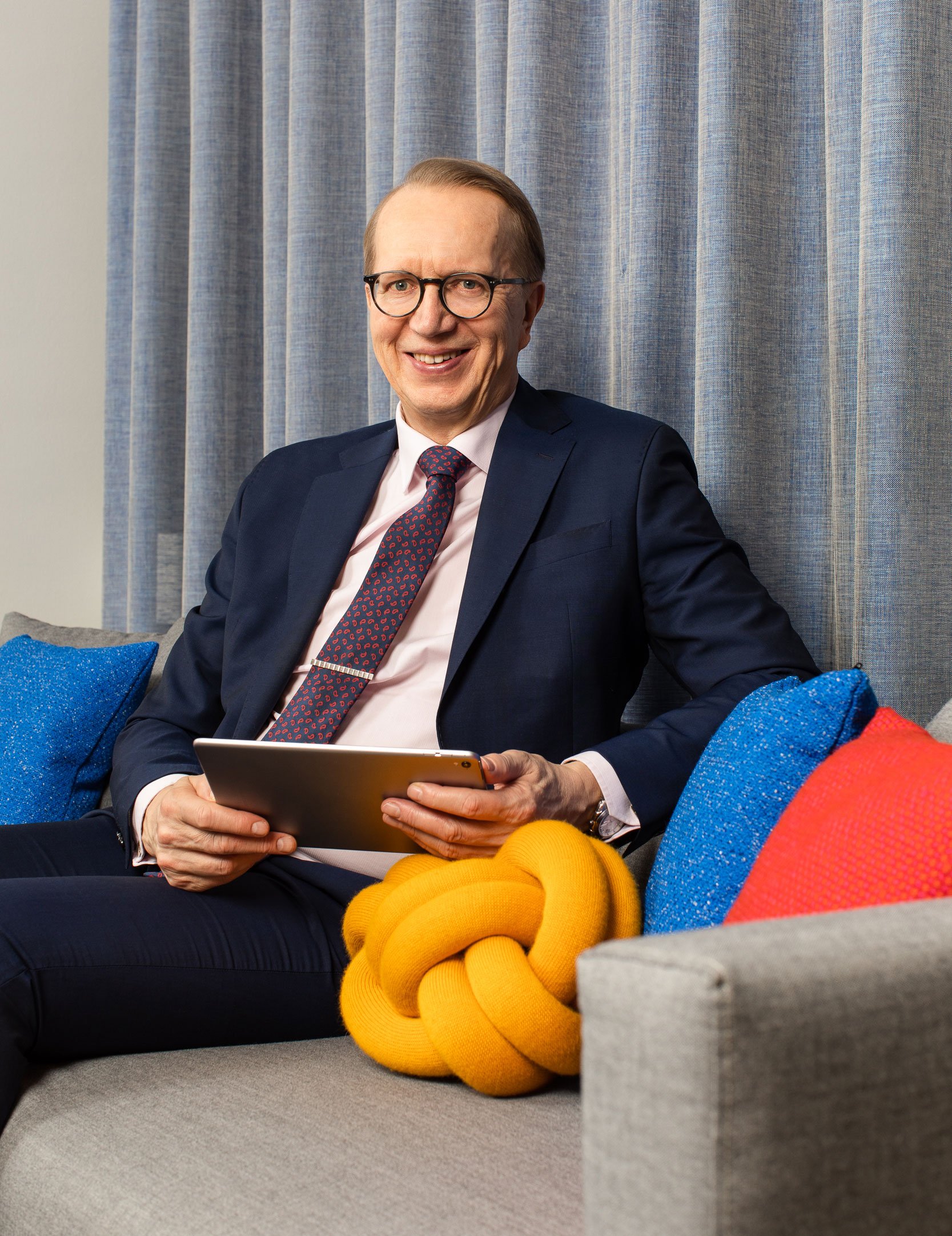 Janne Metsämäki sitting on a couch smiling.